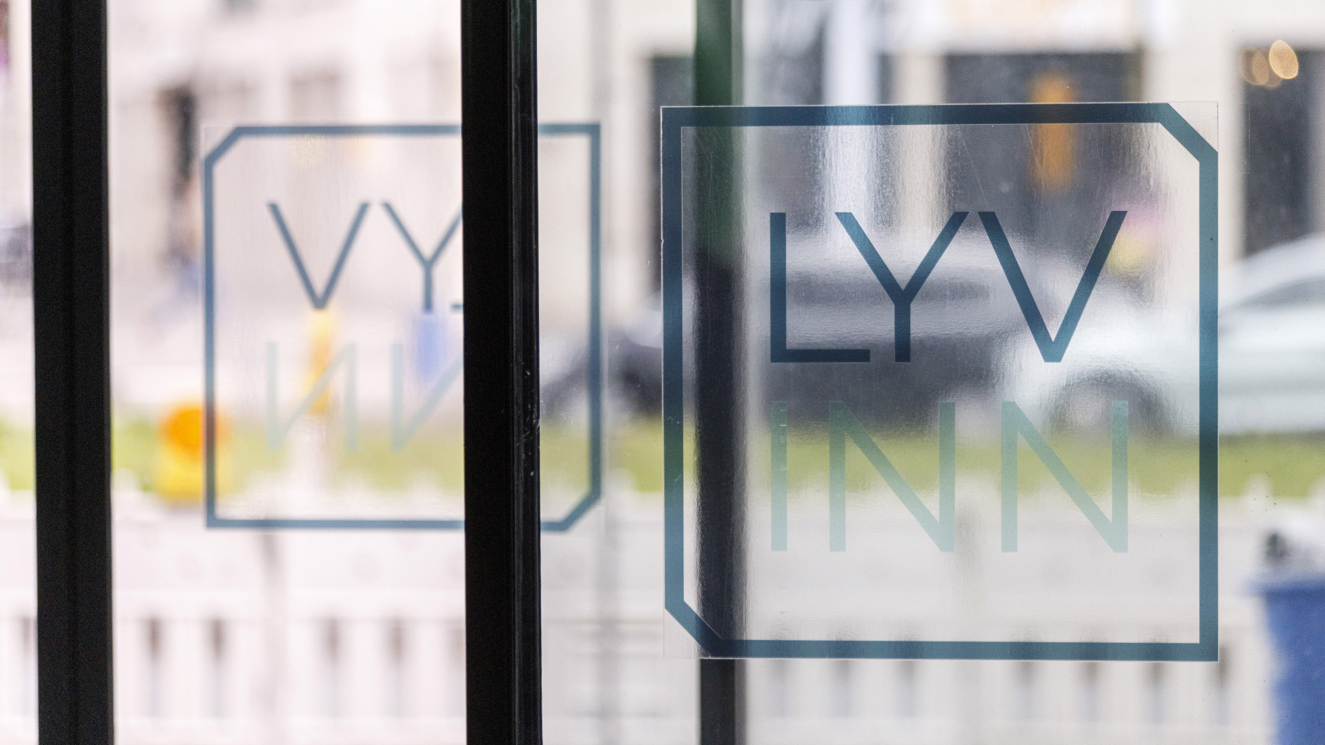 Das LyvInn Logo auf der Glastür des Hoteleingangs.
