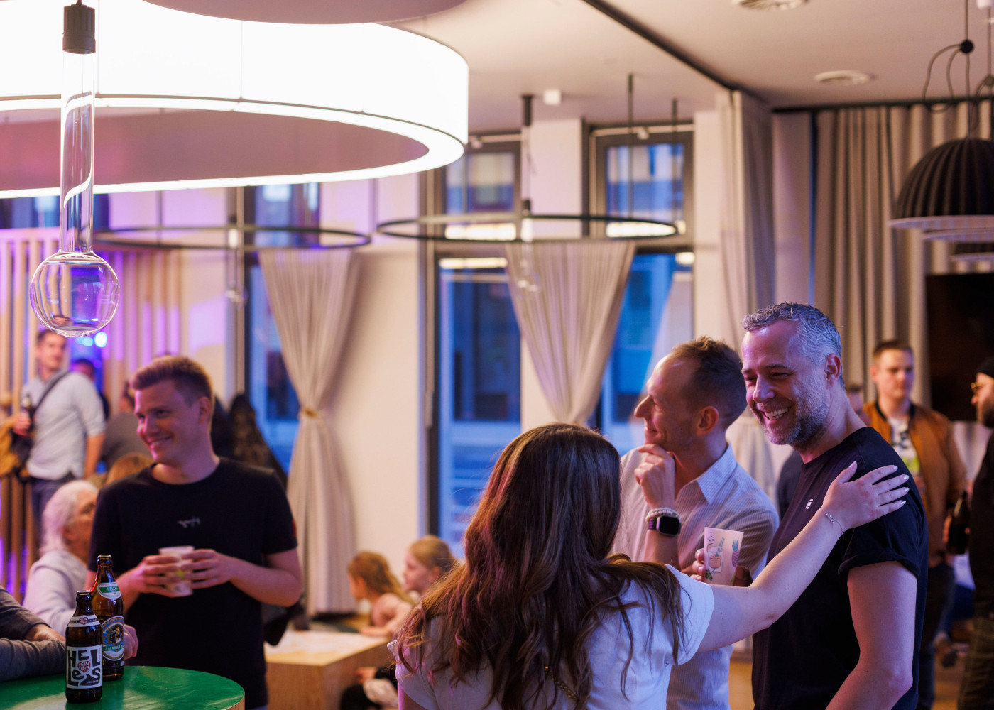 Mehrere Personen stehen in der Hotellobby und unterhalten sich.